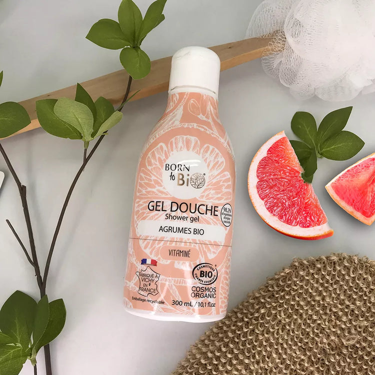 Citrus Shower Gel Certified Organic bottle on a bed of leaves and grapefruit slices, promoting natural cleansing and hydration.